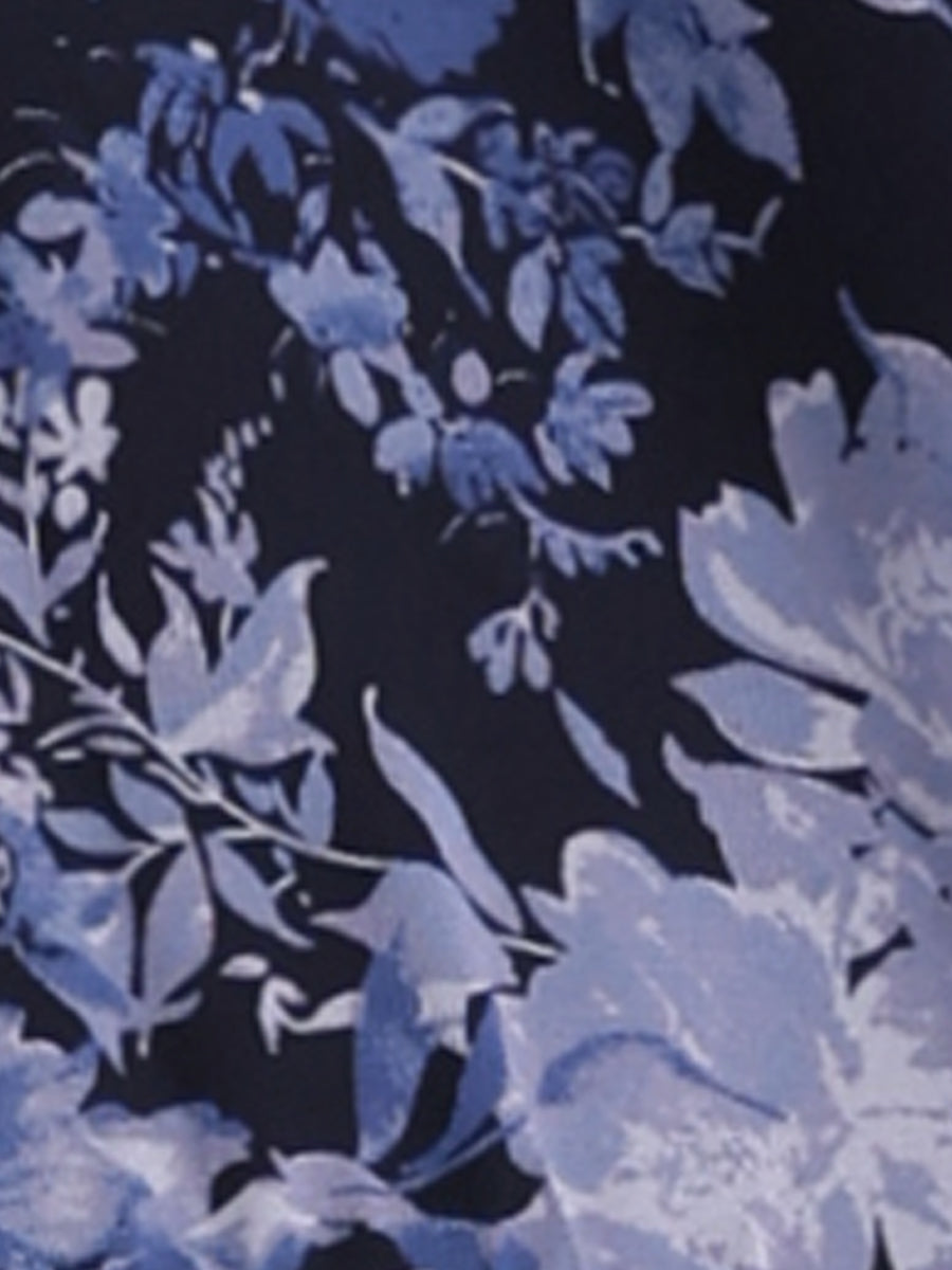 Navy Blue - Woman walking outdoors wearing a sleeveless floral chiffon midi sundress with an asymmetrical high-low ruffle hem.