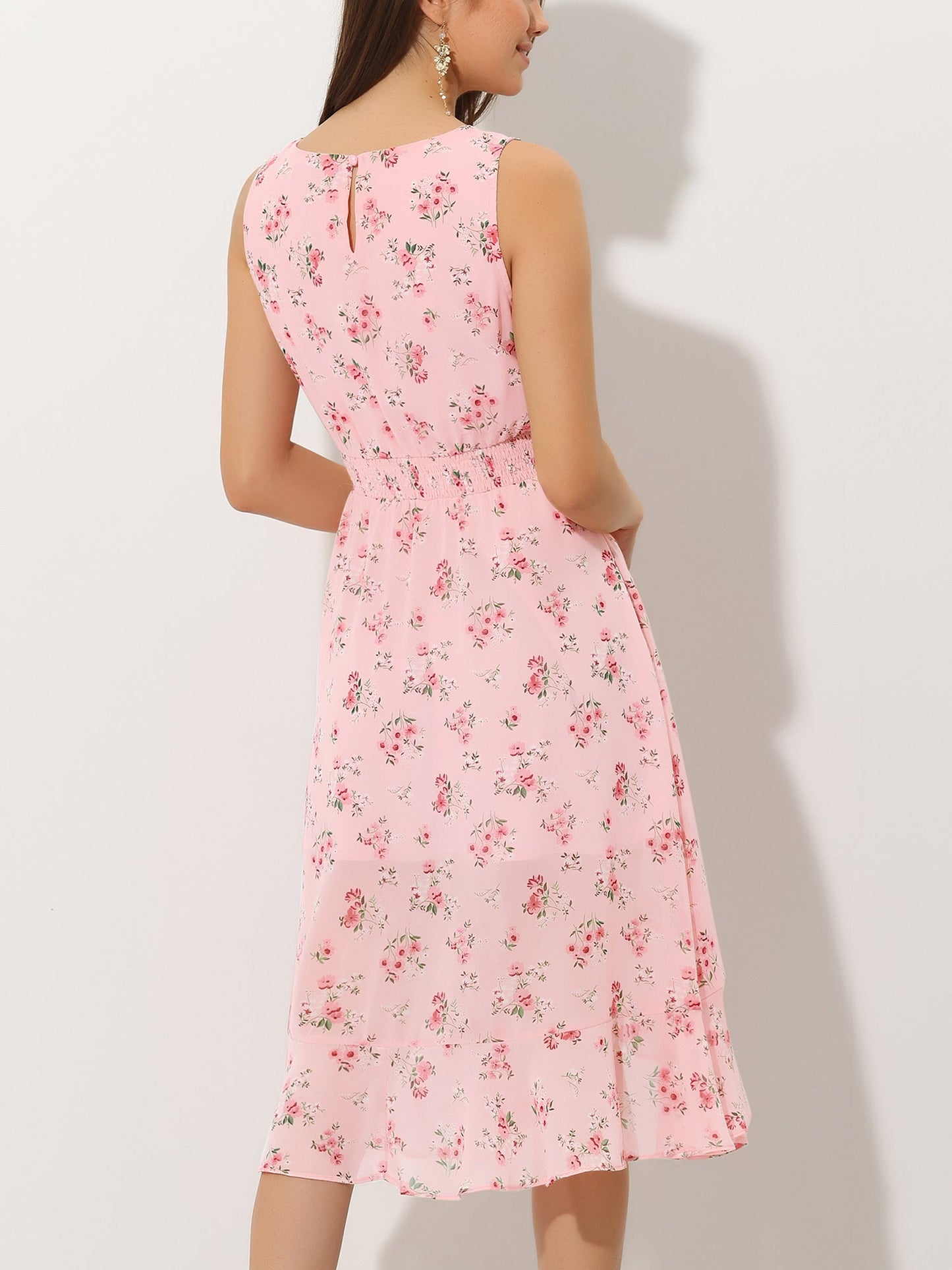 Pink - Woman walking outdoors wearing a sleeveless floral chiffon midi sundress with an asymmetrical high-low ruffle hem.