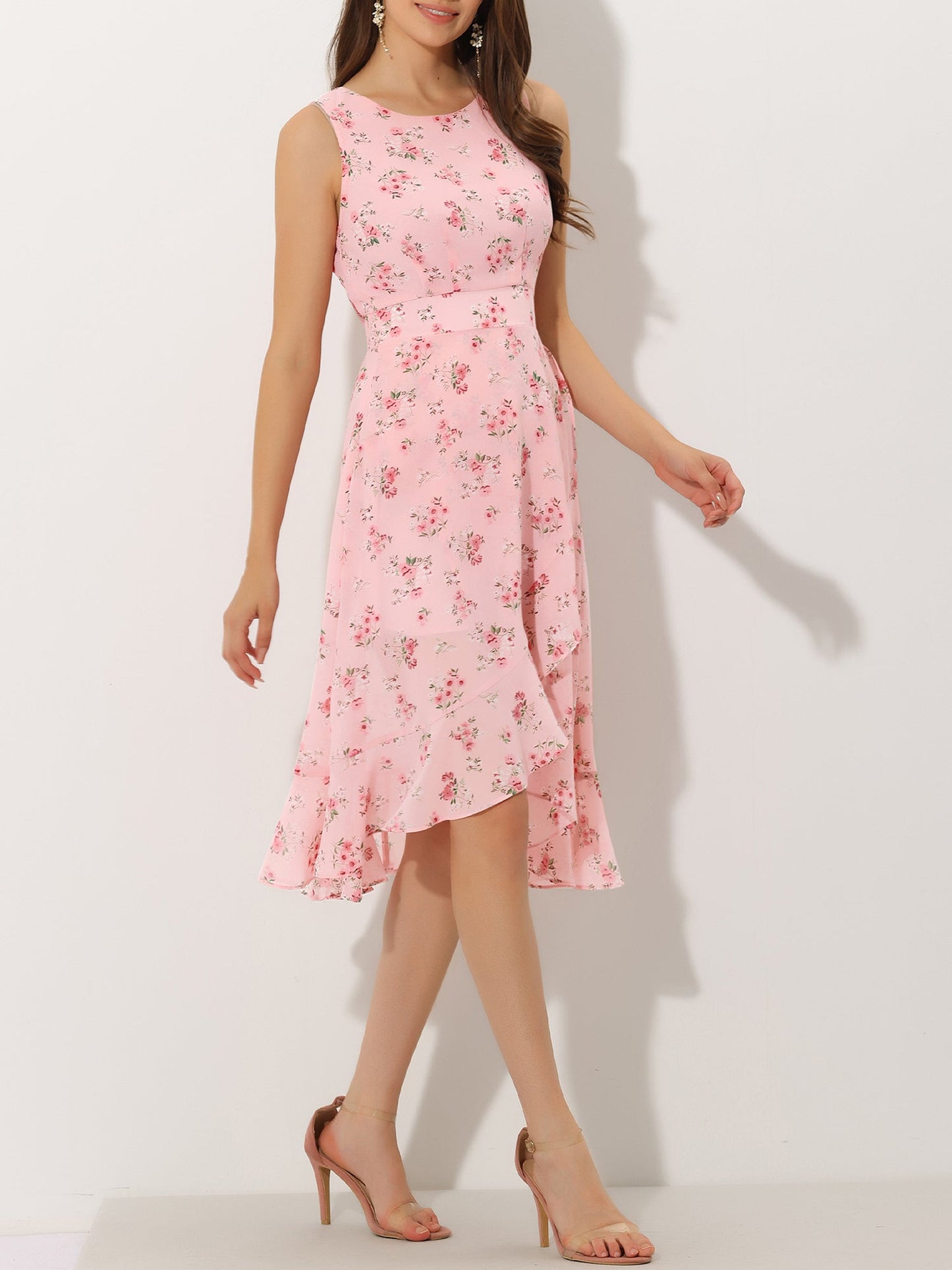 Pink - Woman walking outdoors wearing a sleeveless floral chiffon midi sundress with an asymmetrical high-low ruffle hem.