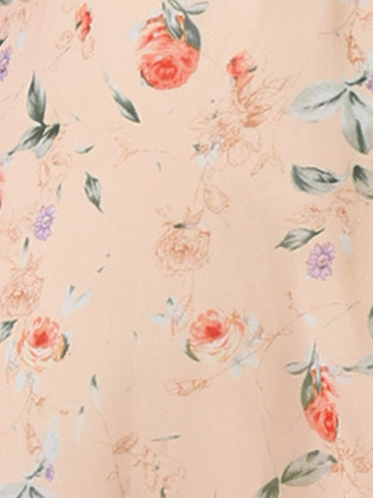 Apricot - Woman walking outdoors wearing a sleeveless floral chiffon midi sundress with an asymmetrical high-low ruffle hem.