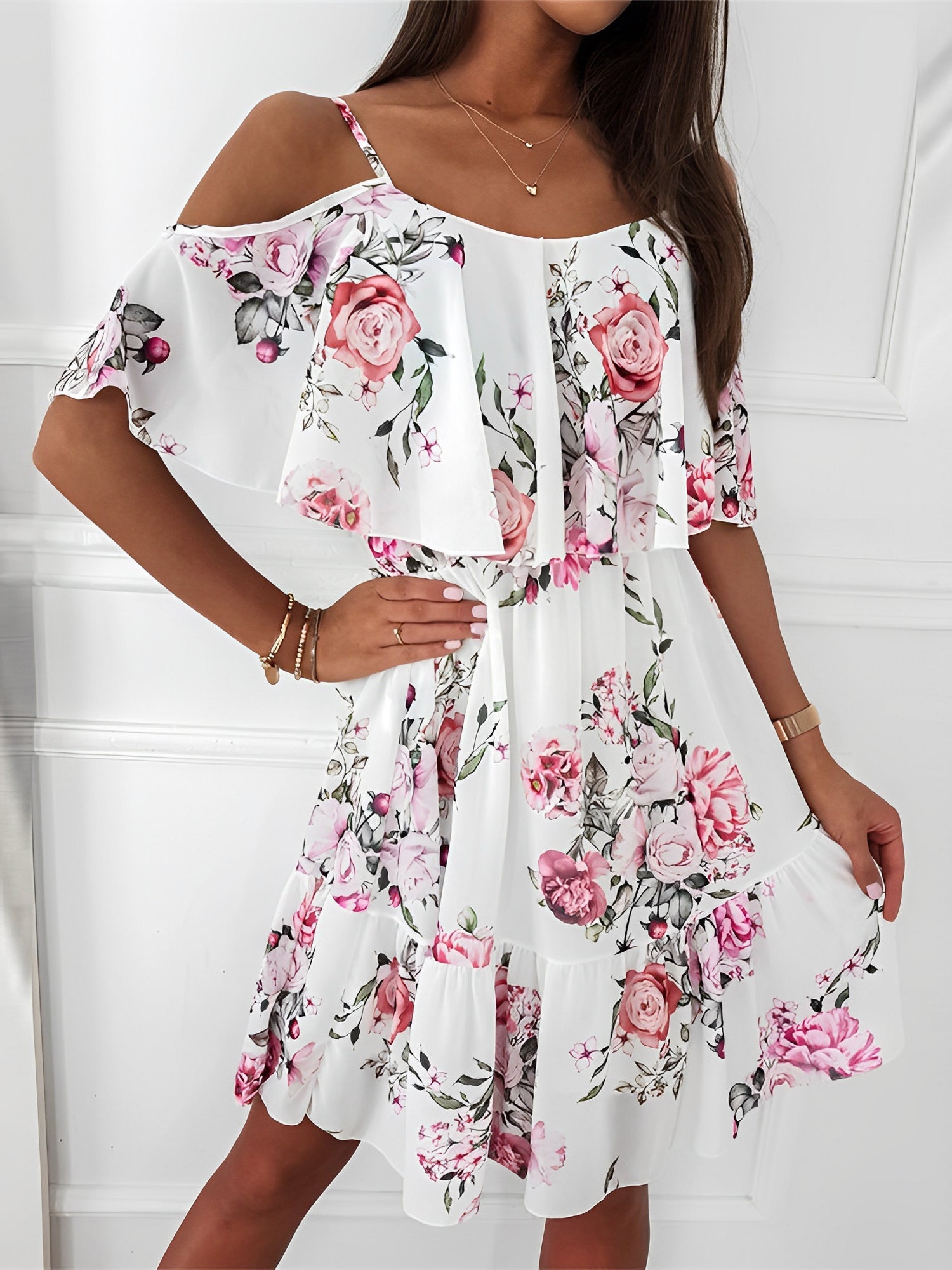 White - Woman wearing a floral print mini sundress with spaghetti straps, a large ruffle bodice overlay, and a tiered skirt