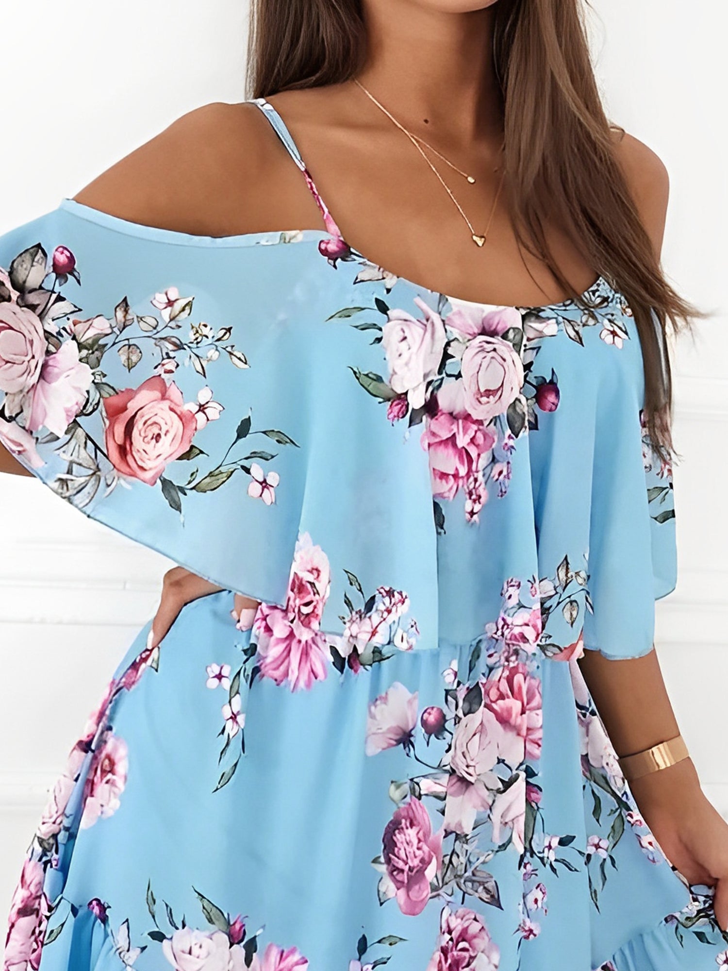 Light Blue - Woman wearing a floral print mini sundress with spaghetti straps, a large ruffle bodice overlay, and a tiered skirt