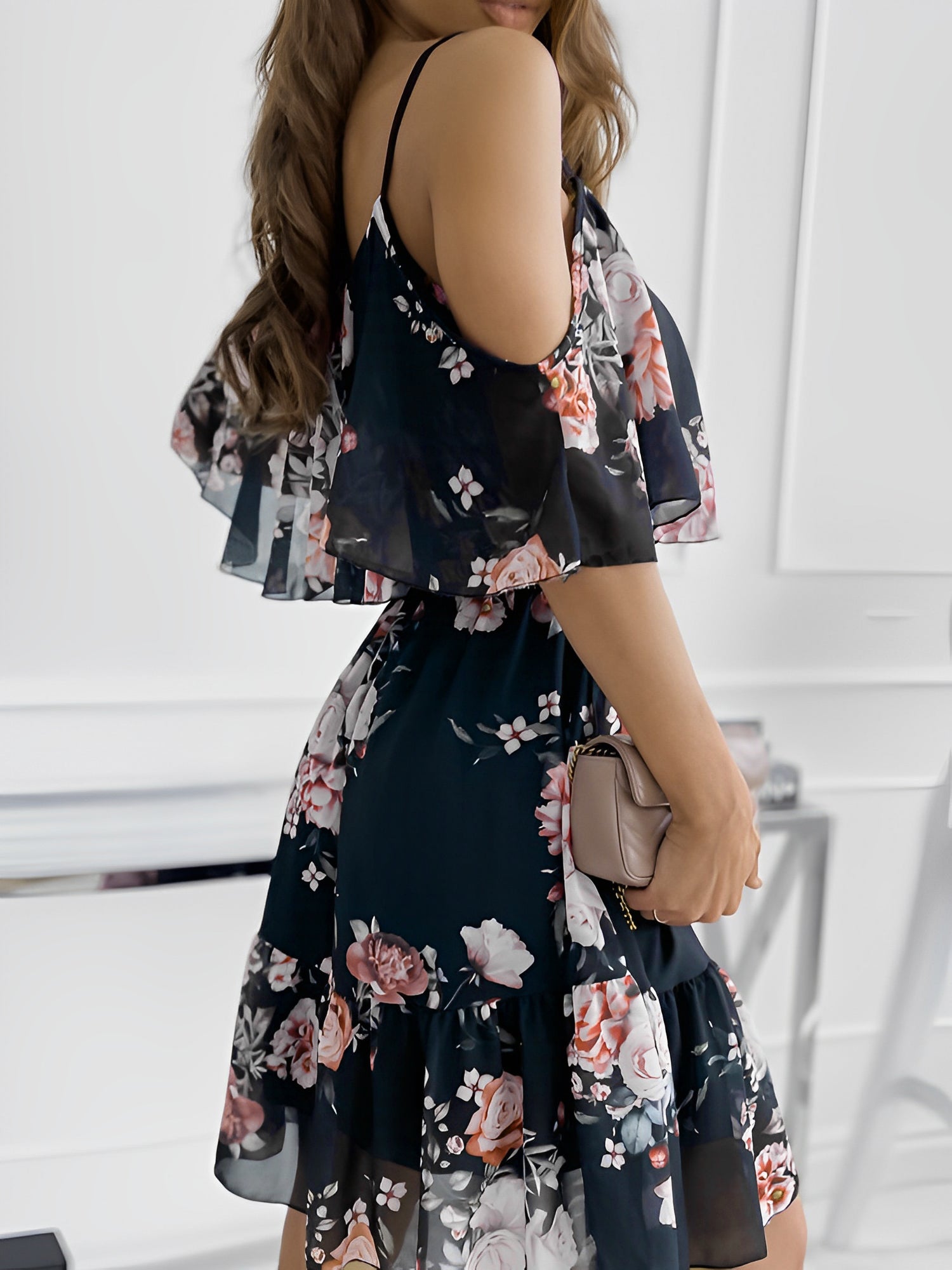 Black - Woman wearing a floral print mini sundress with spaghetti straps, a large ruffle bodice overlay, and a tiered skirt