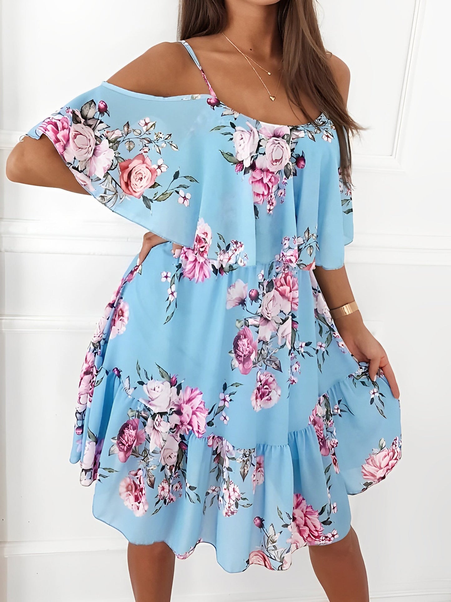 Light Blue - Woman wearing a floral print mini sundress with spaghetti straps, a large ruffle bodice overlay, and a tiered skirt