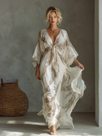 Ivory - Model walking in a flowing, semi-sheer maxi dress featuring a deep V-neckline, wide kimono sleeves, and a large-scale plume print pattern.