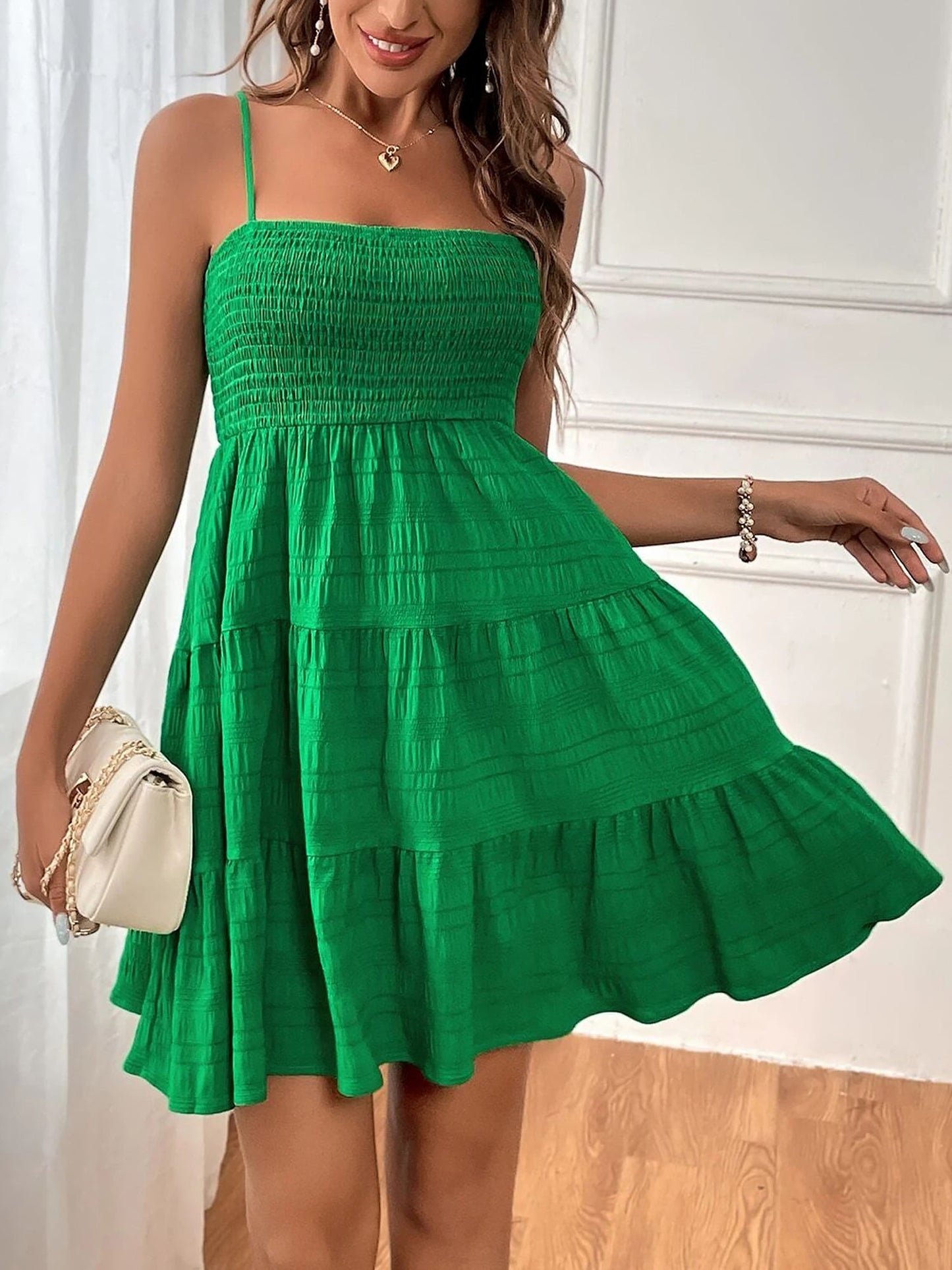 Green - Woman wearing a textured smocked bodice mini dress with spaghetti straps and a tiered skirt