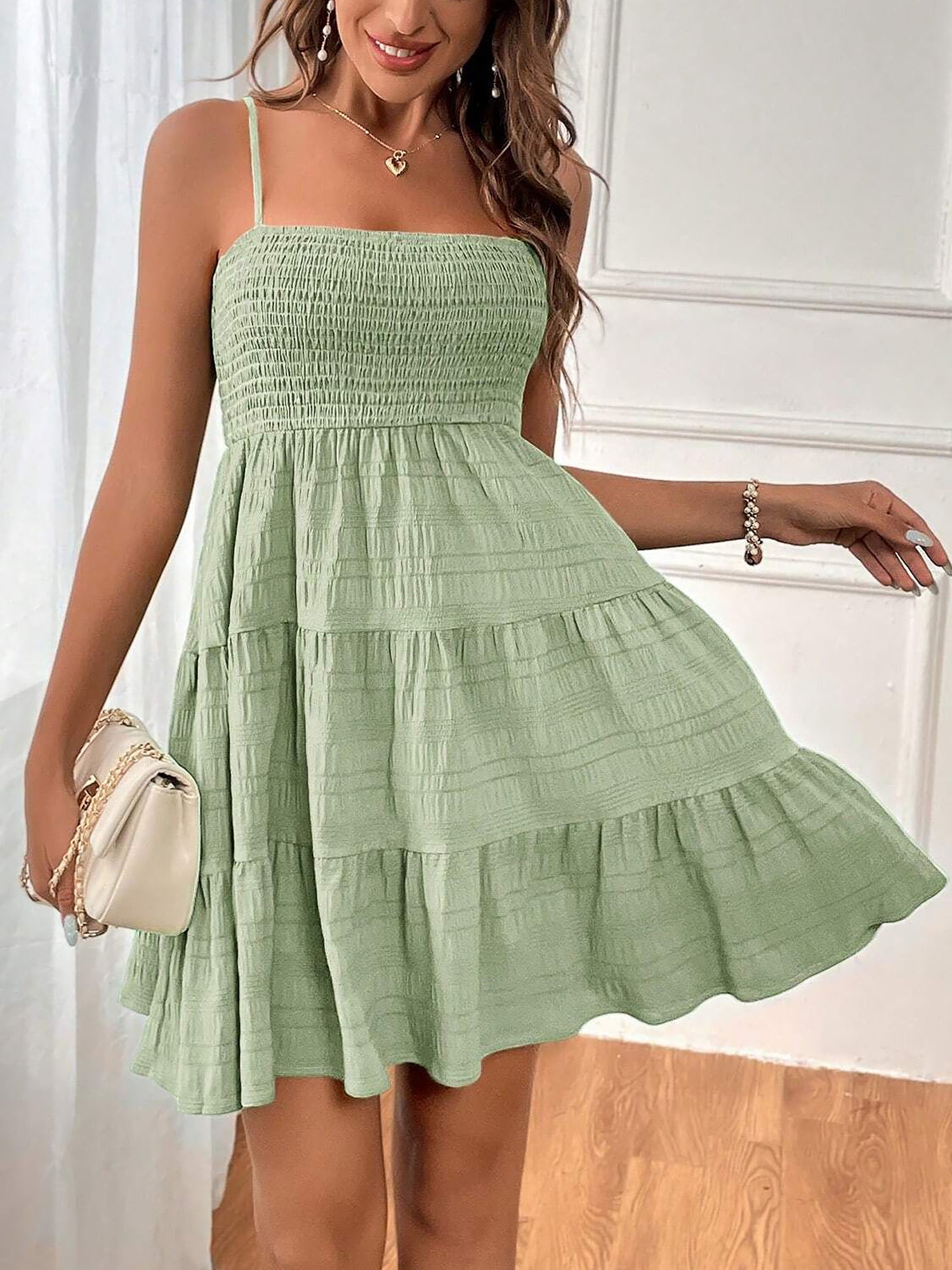 Light Green - Woman wearing a textured smocked bodice mini dress with spaghetti straps and a tiered skirt