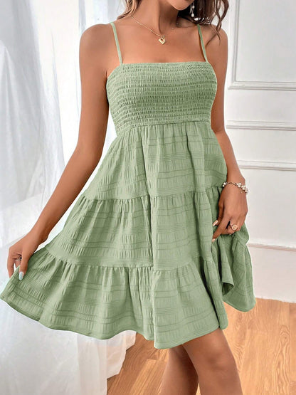 Light Green - Woman wearing a textured smocked bodice mini dress with spaghetti straps and a tiered skirt