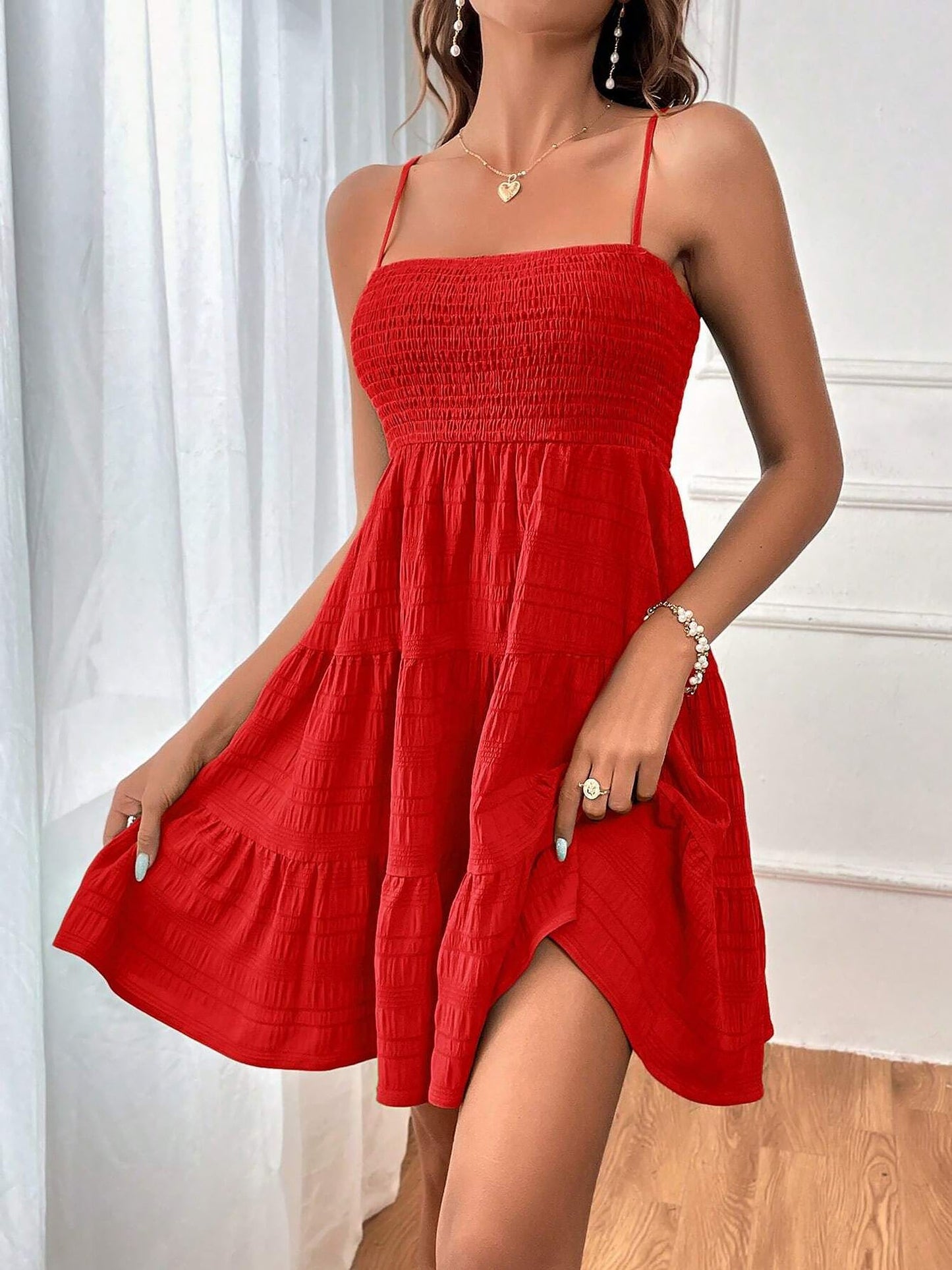 Red - Woman wearing a textured smocked bodice mini dress with spaghetti straps and a tiered skirt