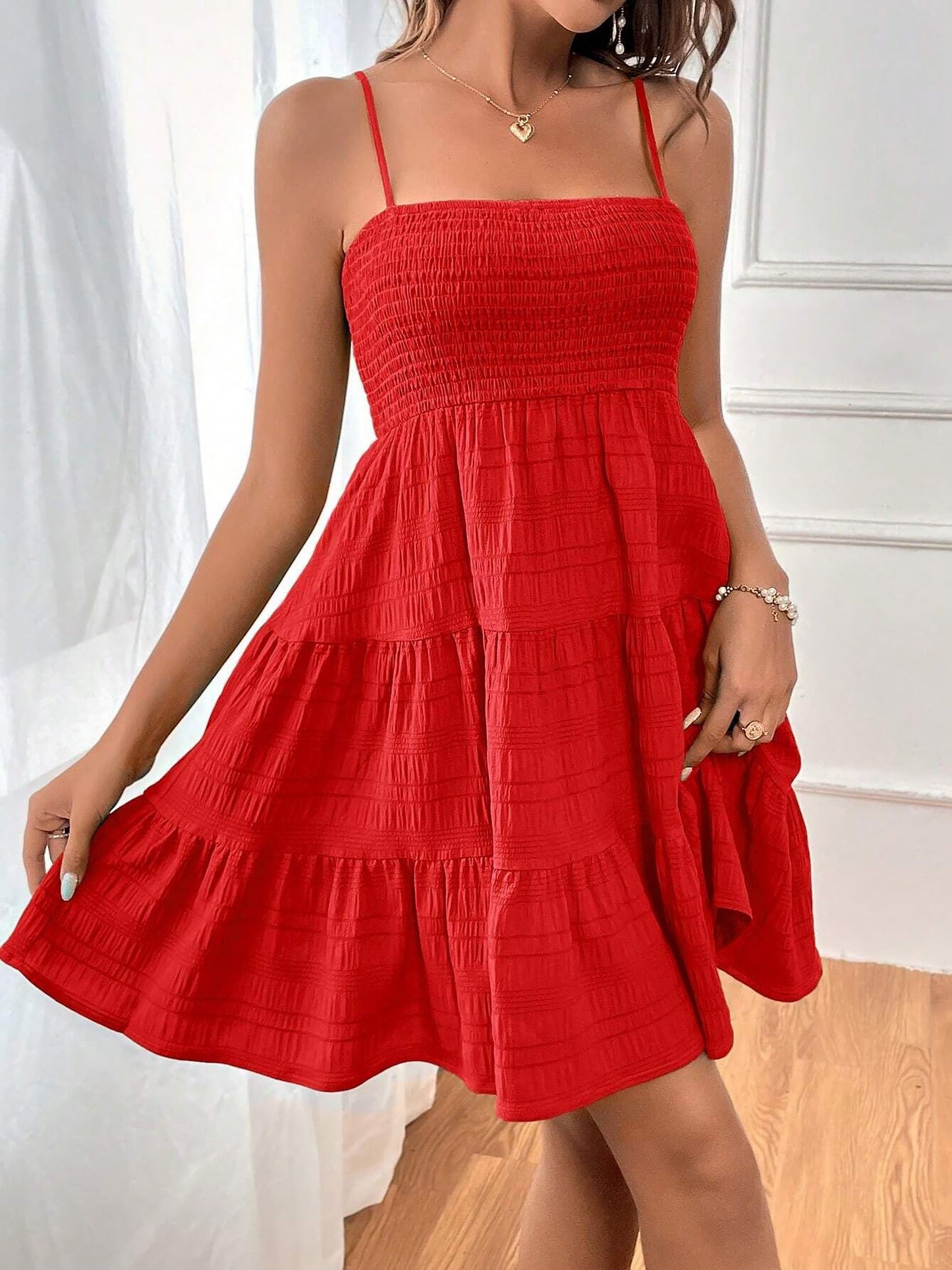 Red - Woman wearing a textured smocked bodice mini dress with spaghetti straps and a tiered skirt