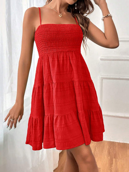 Red - Woman wearing a textured smocked bodice mini dress with spaghetti straps and a tiered skirt
