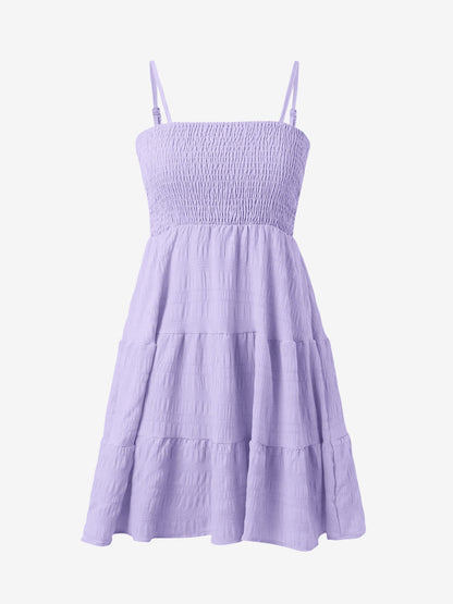 Light Purple - Woman wearing a textured smocked bodice mini dress with spaghetti straps and a tiered skirt