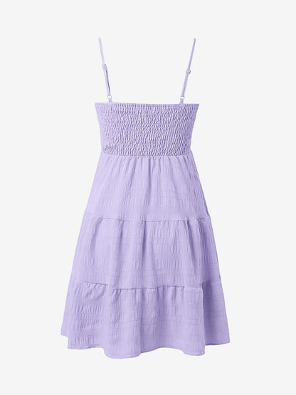 Light Purple - Woman wearing a textured smocked bodice mini dress with spaghetti straps and a tiered skirt