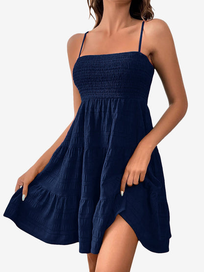 Navy Blue - Woman wearing a textured smocked bodice mini dress with spaghetti straps and a tiered skirt