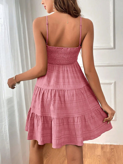 Pink - Woman wearing a textured smocked bodice mini dress with spaghetti straps and a tiered skirt