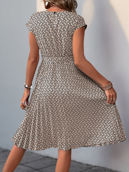 Khaki - Woman wearing a floral print midi dress featuring cap sleeves, a tie waist sash, and a finely pleated skirt.