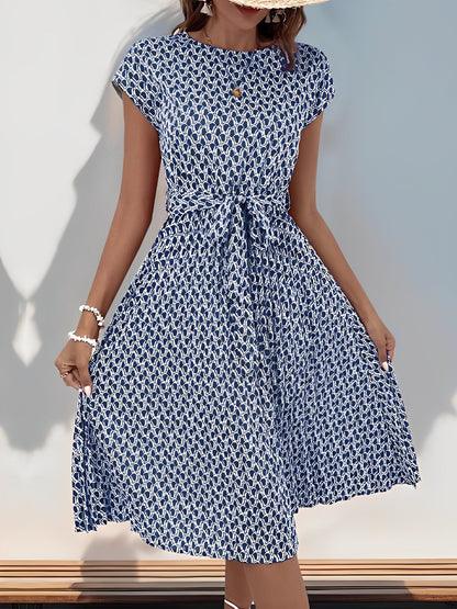 Navy Blue - Woman wearing a floral print midi dress featuring cap sleeves, a tie waist sash, and a finely pleated skirt.