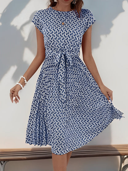 Navy Blue - Woman wearing a floral print midi dress featuring cap sleeves, a tie waist sash, and a finely pleated skirt.