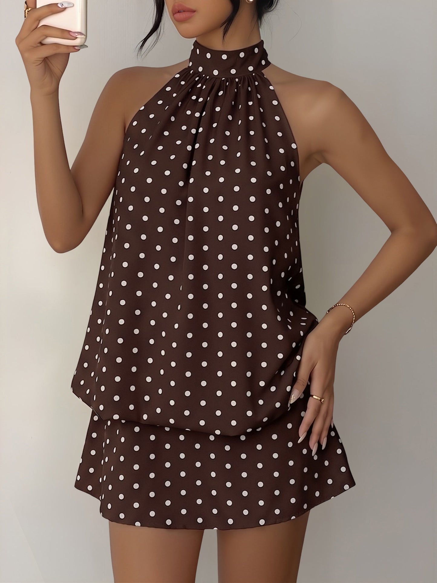 Coffee - Woman modeling a sleeveless halter neck mini dress with a polka dot print and blouson top
