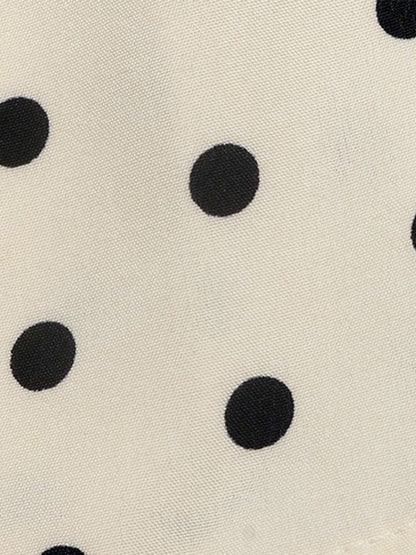 Apricot - Woman modeling a sleeveless halter neck mini dress with a polka dot print and blouson top