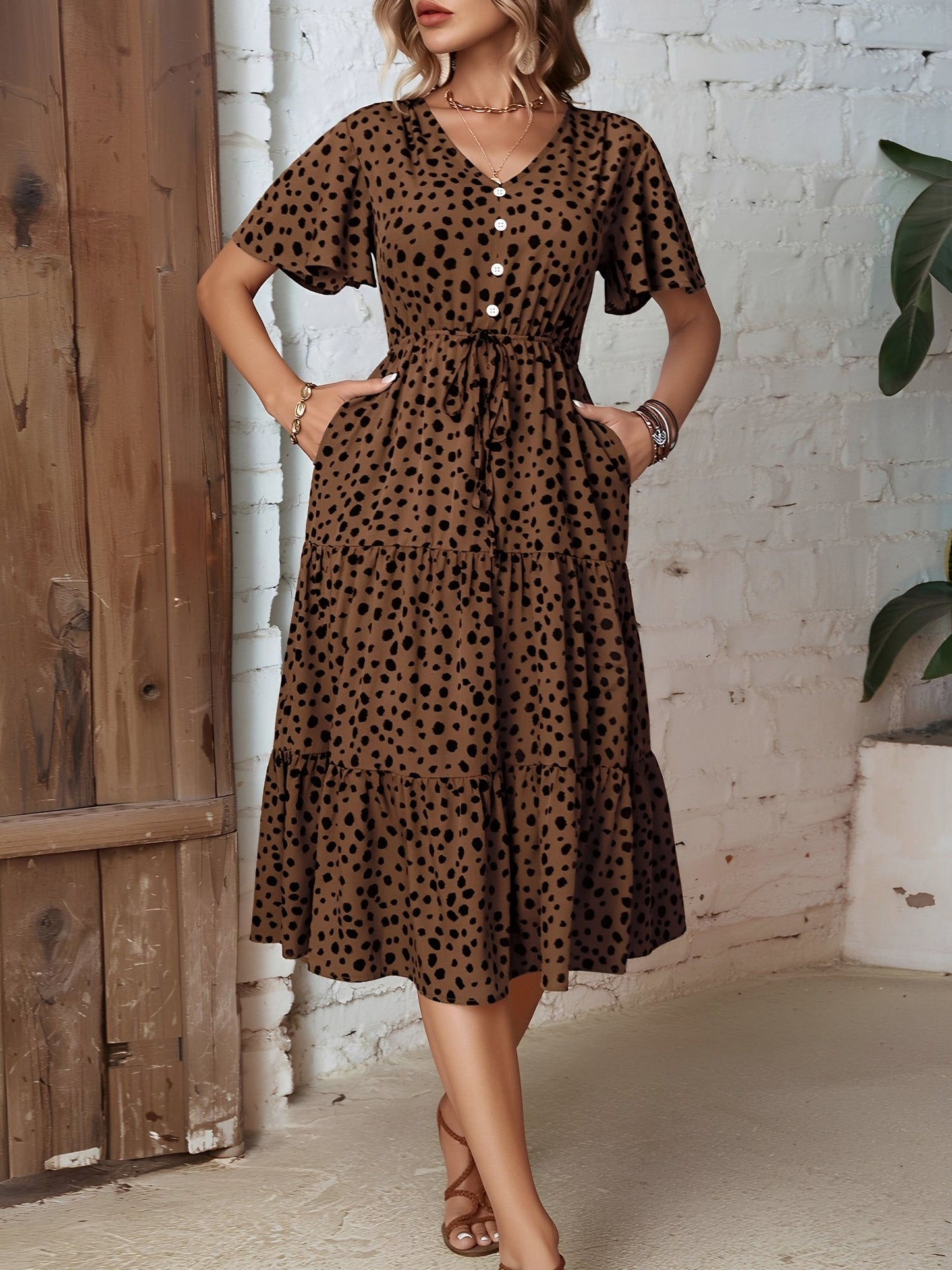 Leopard - Woman wearing a polka dot V-neck midi dress with a tie waist and a tiered skirt featuring side pockets.