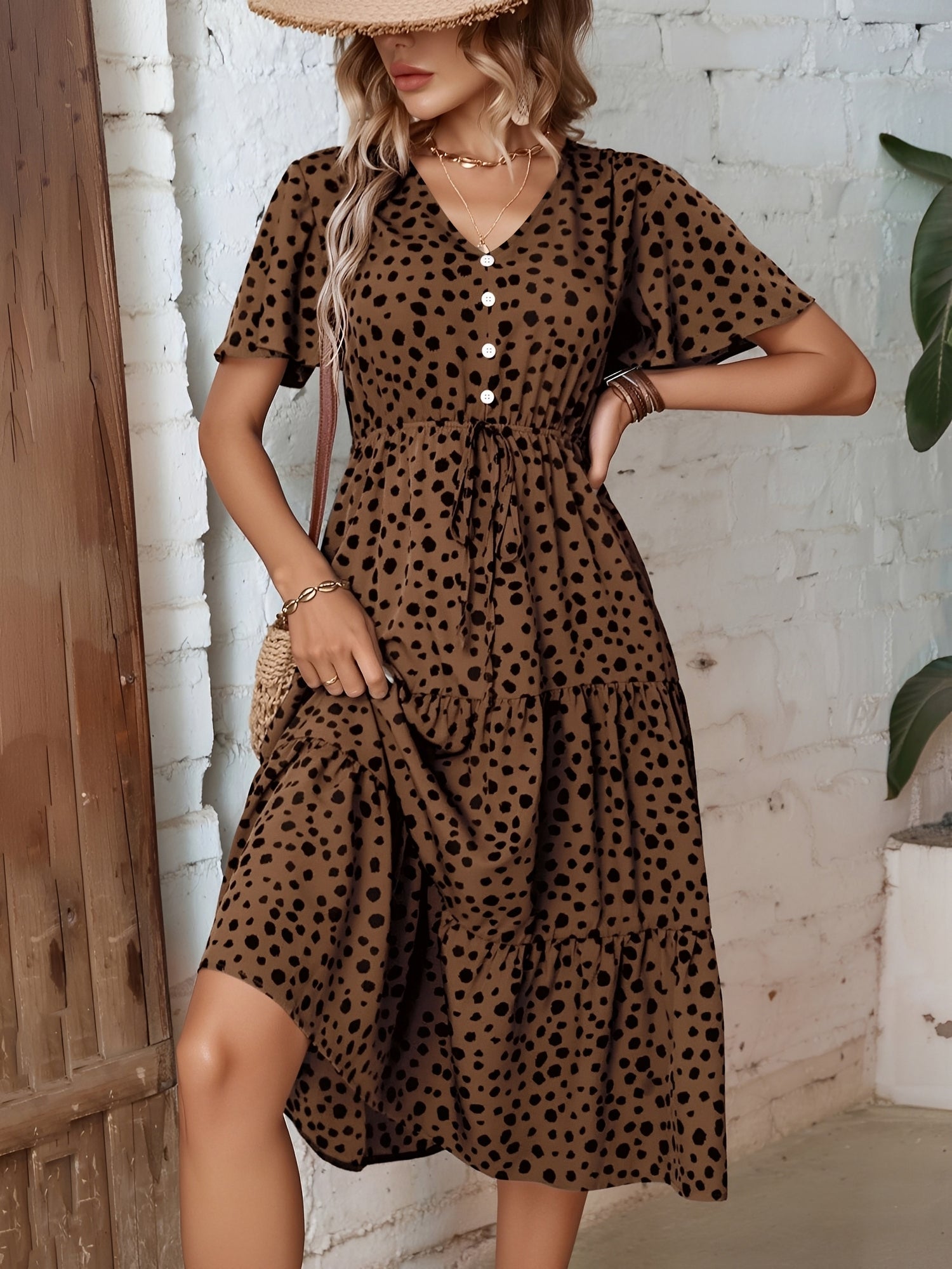 Leopard - Woman wearing a polka dot V-neck midi dress with a tie waist and a tiered skirt featuring side pockets.