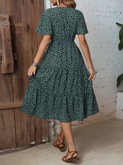 Dark Green - Woman wearing a polka dot V-neck midi dress with a tie waist and a tiered skirt featuring side pockets.