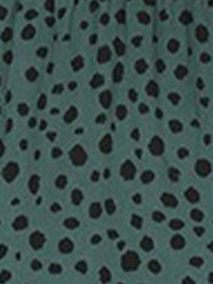 Dark Green - Woman wearing a polka dot V-neck midi dress with a tie waist and a tiered skirt featuring side pockets.