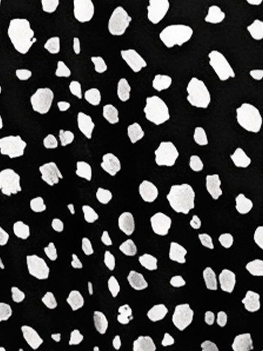 Black - Woman wearing a polka dot V-neck midi dress with a tie waist and a tiered skirt featuring side pockets.
