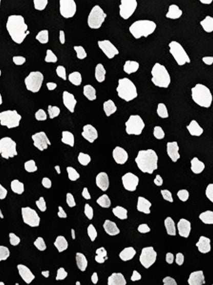 Black - Woman wearing a polka dot V-neck midi dress with a tie waist and a tiered skirt featuring side pockets.