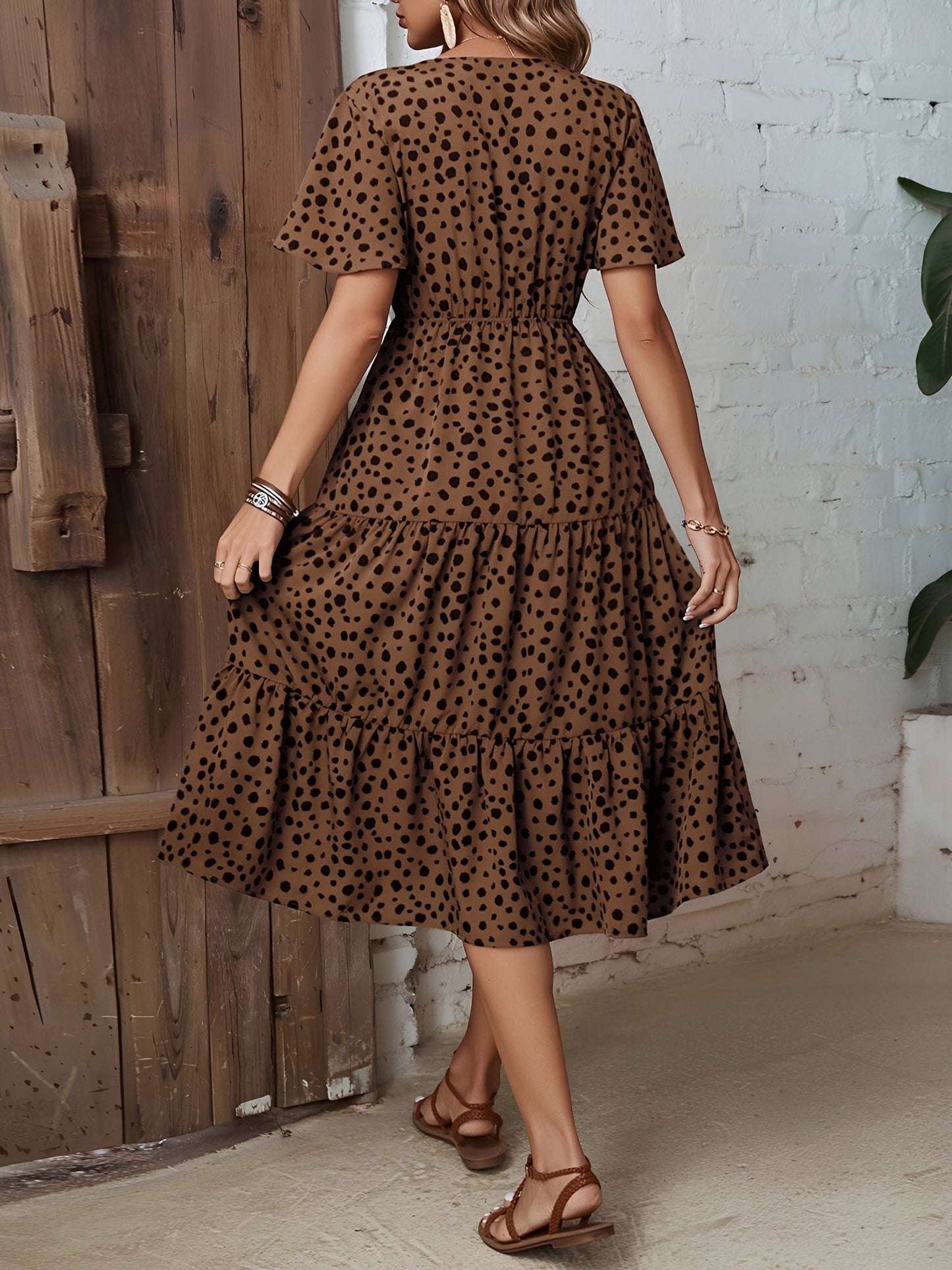 Leopard - Woman wearing a polka dot V-neck midi dress with a tie waist and a tiered skirt featuring side pockets.