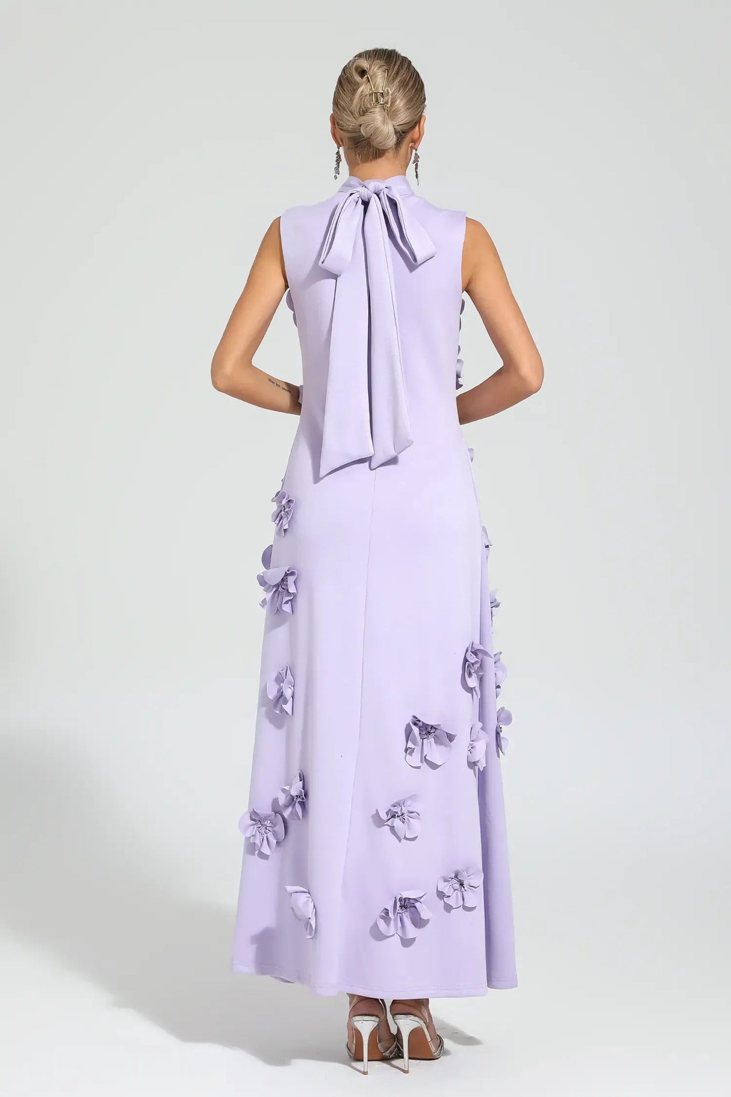 Purple - Sleeveless high neck maxi dress featuring a structured column silhouette and cascading dimensional floral appliques across the front bodice and skirt.