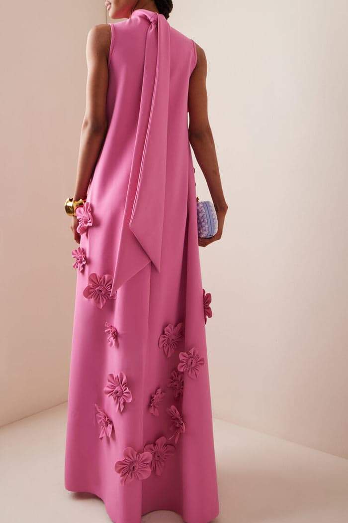 Pink - Sleeveless high neck maxi dress featuring a structured column silhouette and cascading dimensional floral appliques across the front bodice and skirt.