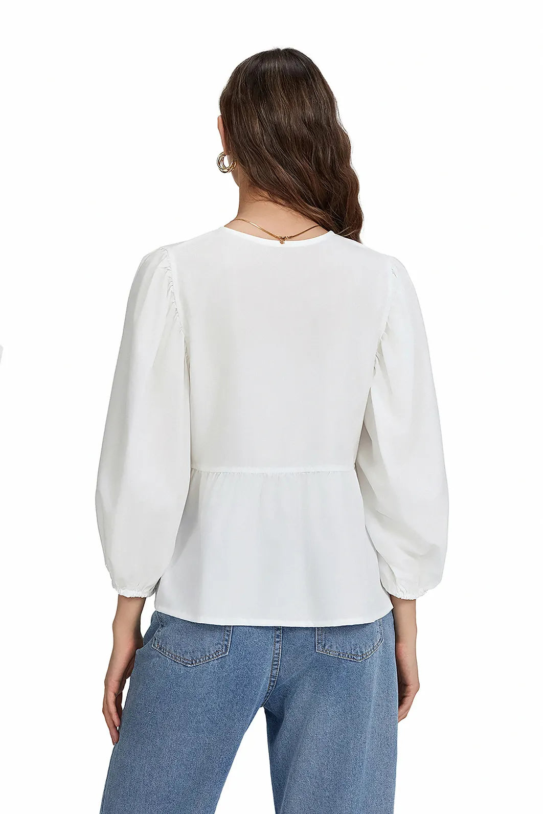 Woman wearing white cotton tie-front peplum blouse and jeans