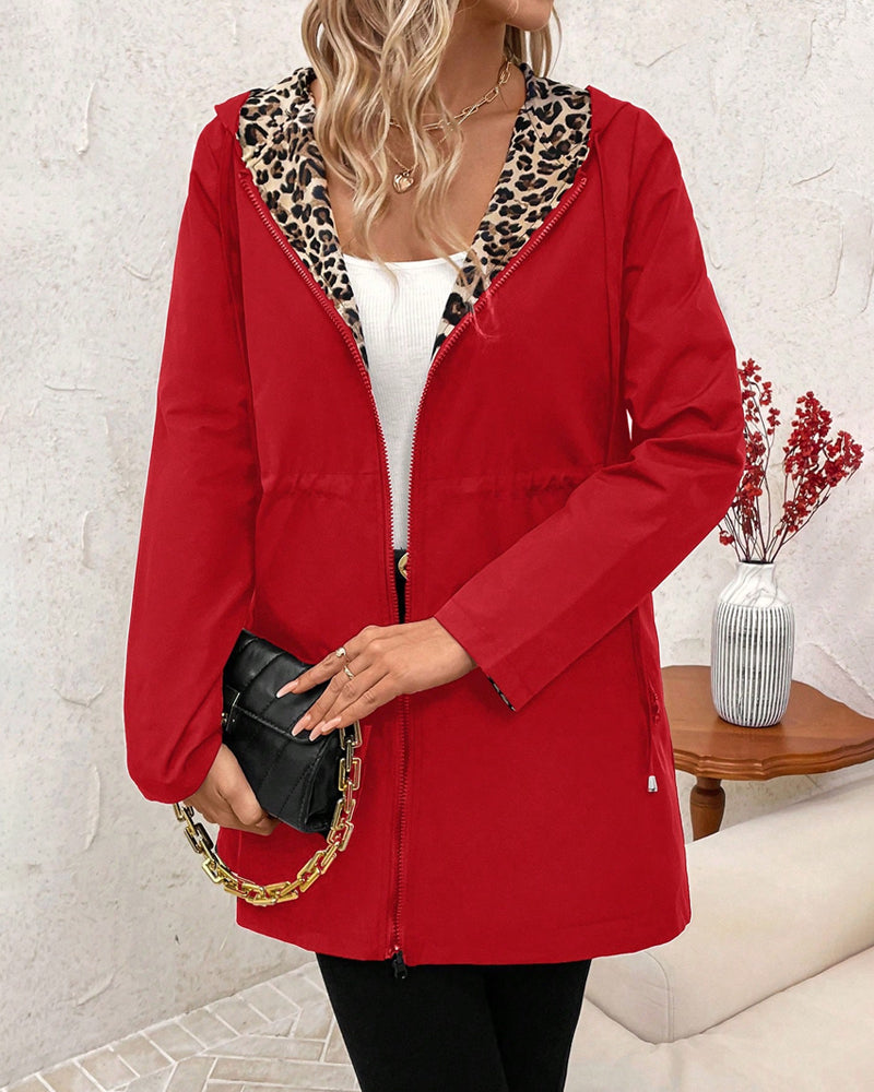 Black Polka - Women's mid-length red zip-up anorak jacket worn open to reveal a bold leopard print interior lining, featuring front pockets and an internal drawstring waist.