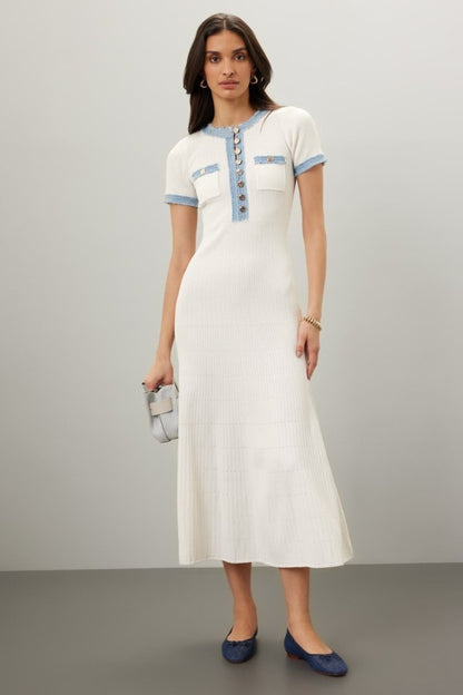 White - Full-length view of a woman wearing a short-sleeved, cream ribbed knit midi dress featuring a blue frayed trim on the crew neck, button placket, and chest pockets.