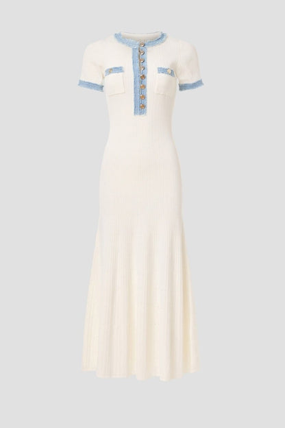 White - Full-length view of a woman wearing a short-sleeved, cream ribbed knit midi dress featuring a blue frayed trim on the crew neck, button placket, and chest pockets.