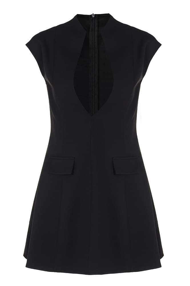 A woman models a black structured mini blazer dress featuring a high mock neck, a deep plunging keyhole cutout, extended cap sleeves, and a flared A-line skirt with flap pockets.