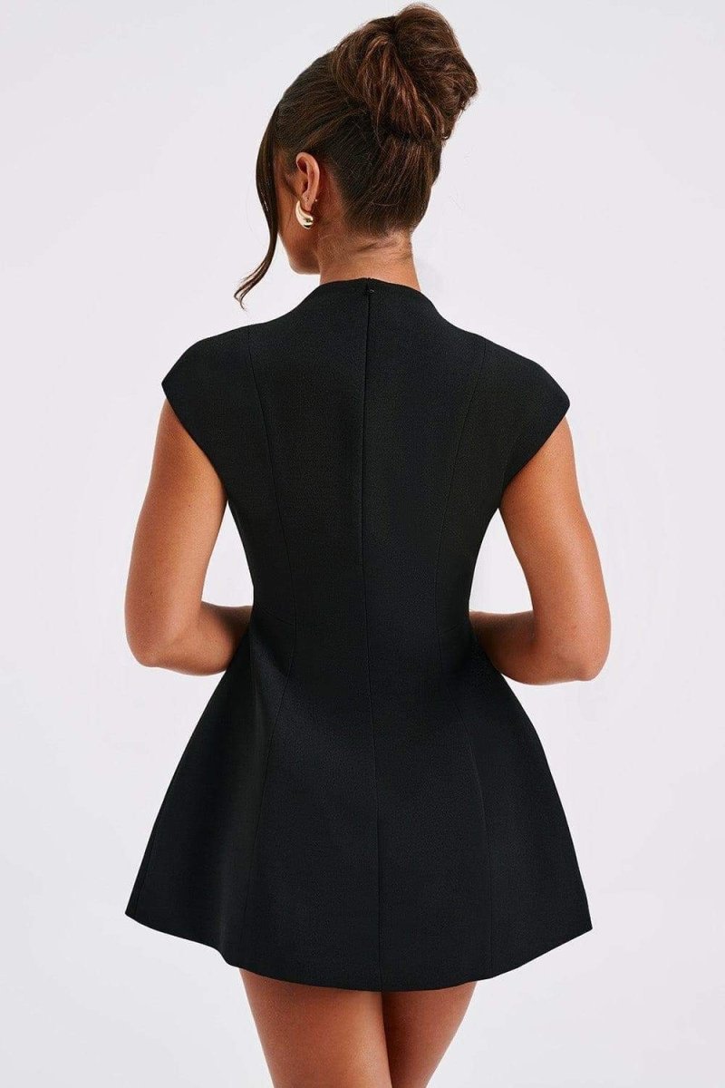 A woman models a black cap-sleeve mini blazer dress featuring a high collar, a deep plunging V-neckline, and a flared A-line skirt.