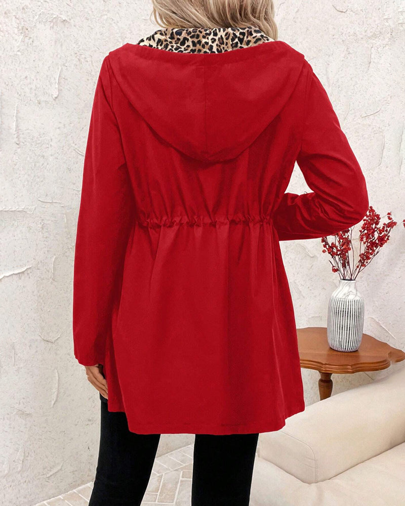 Black Polka - Women's mid-length red zip-up anorak jacket worn open to reveal a bold leopard print interior lining, featuring front pockets and an internal drawstring waist.