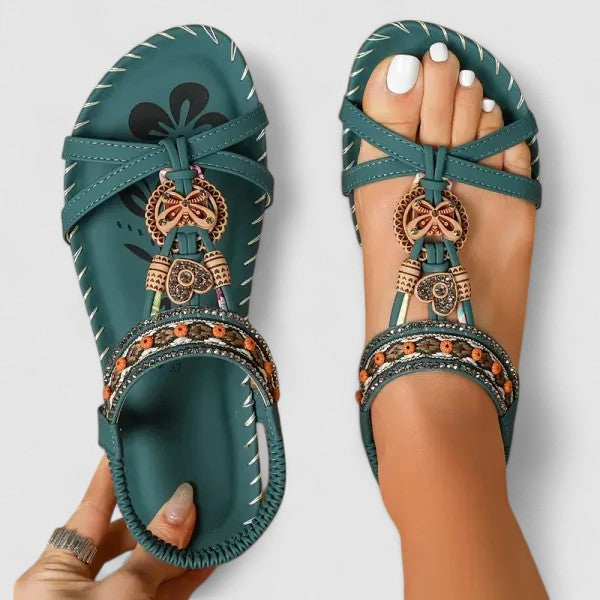Amazon Green - Flat open-toe sandals featuring intricate beaded medallions, contrast stitching along the sole, and an elasticized slingback strap.