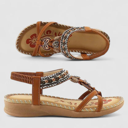 Beige Bali - Flat open-toe sandals featuring intricate beaded medallions, contrast stitching along the sole, and an elasticized slingback strap.