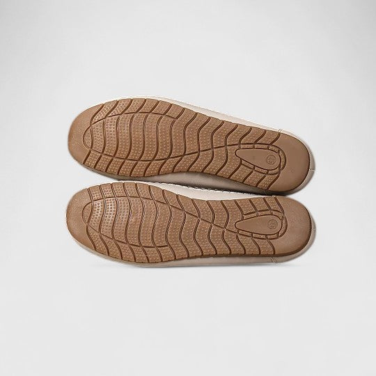 White - Women's slip-on loafers featuring a faux-leather upper with intricate floral cutouts and a flat, textured sole.