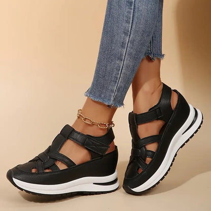 Black - Women's faux-leather orthopedic platform sandals featuring a woven cut-out upper design, adjustable heel strap, and thick cushioned sole, modeled on feet.