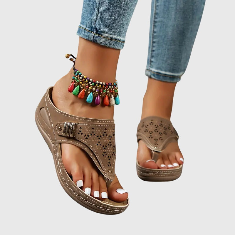 Khaki - Faux-leather wedge sandals featuring a slip-on thong design, laser-cut upper detailing, decorative metallic buckle, and prominent contrast stitching along a thick shock-absorbing sole.