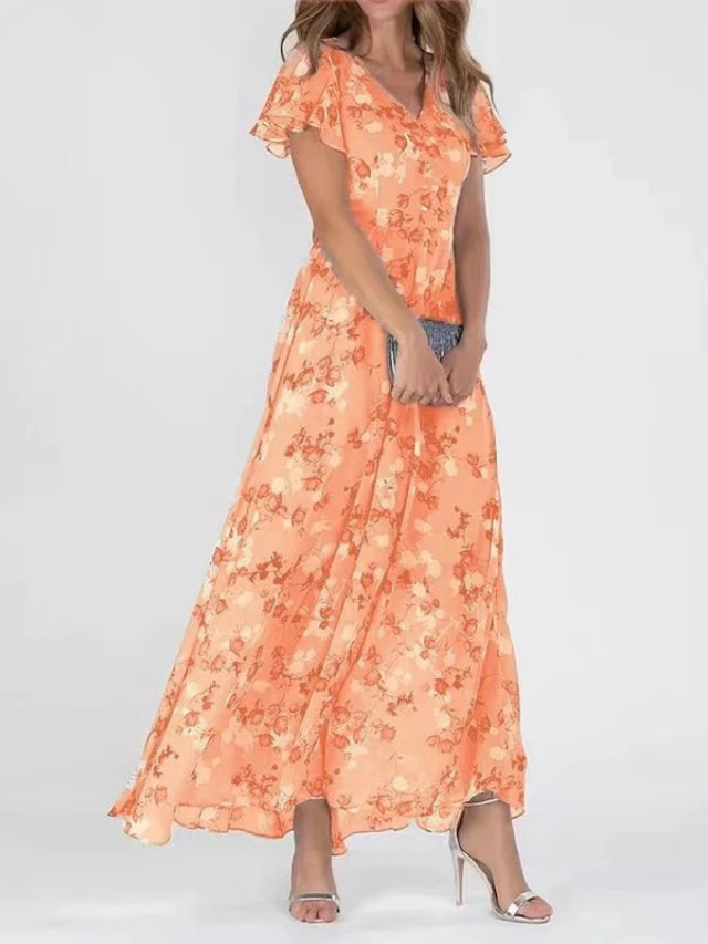 Orange - A woman wearing a peach-colored floral print chiffon maxi dress with flutter sleeves and a V-neck, showcasing a fluid, sweeping skirt.