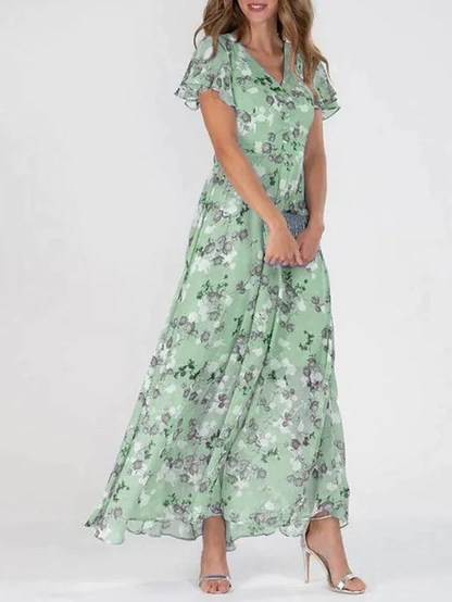 Light Green - A woman wearing a peach-colored floral print chiffon maxi dress with flutter sleeves and a V-neck, showcasing a fluid, sweeping skirt.