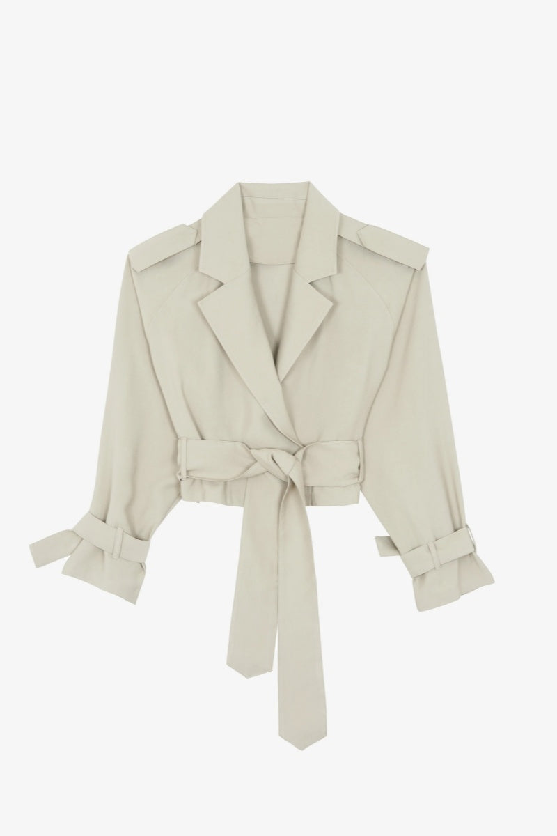 Cement - Women's cropped wrap trench jacket featuring a self-tie waist belt, wide lapels, shoulder epaulettes, and adjustable cuff straps in a fluid, relaxed fit.