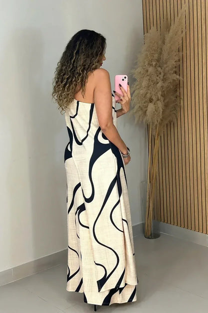 Woman in cream and black abstract print one-shoulder maxi dress