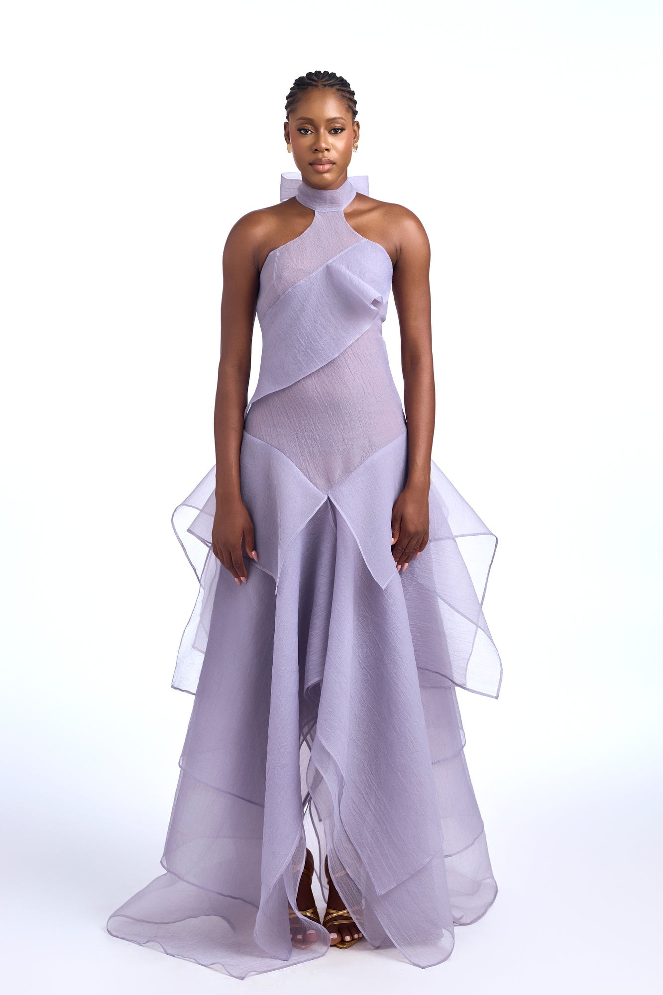 Purple - A woman wearing an elegant, floor-length gown featuring a high halter neckline, an asymmetrical layered bodice, and a voluminous tiered skirt made of sheer, crisp fabric.